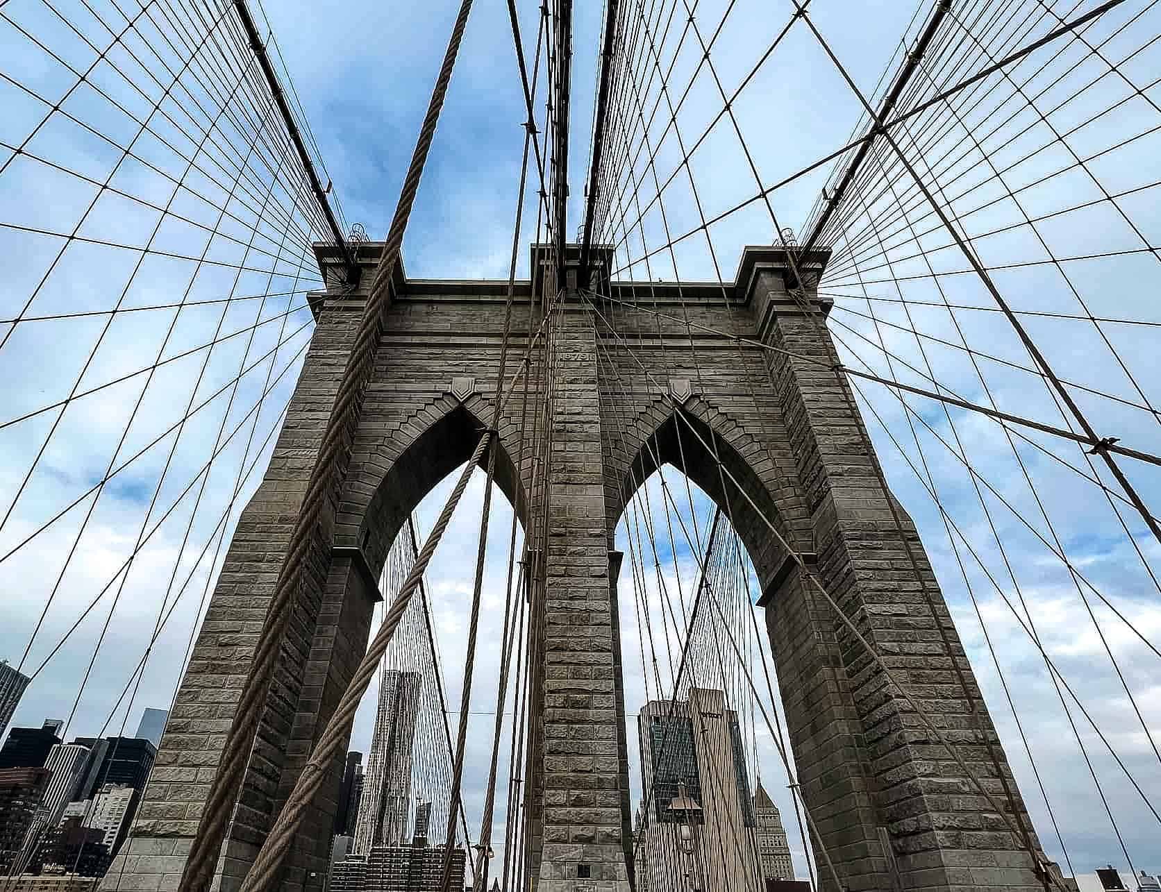 New York City in Winter - A Guide to Visiting New York City in Winter Brooklyn Bridge with steel cable construction - New York City, USA.